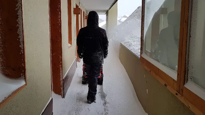 A man clears heavy snow with a machine in La Plagne, Plagne Soleil