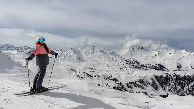 Intermediate skier standing above La Plagne vista