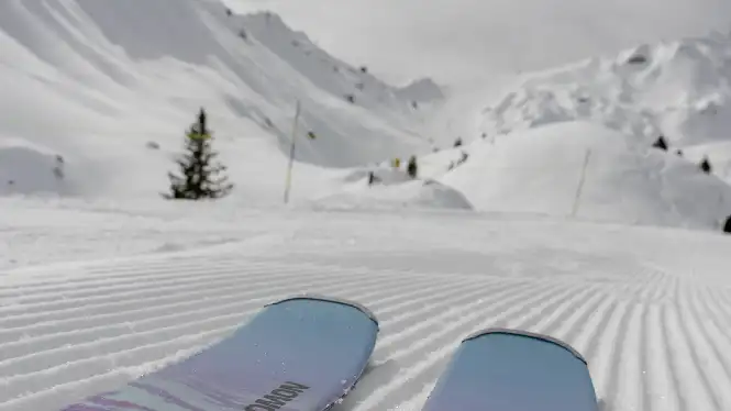 Skier stands on pisted slope in La Plagne