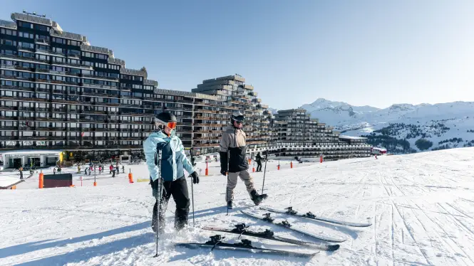 Two beginner skiers at Aime 2000 La Plagne putting on skis